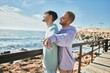 © Krakenimages.com - Young gay couple breathing with arms opened at the beach.