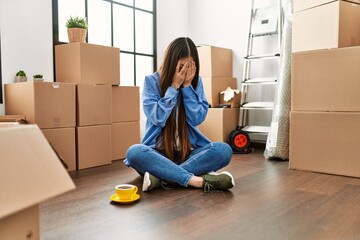 Sticker - Young chinese girl sitting on the floor at new home with sad expression covering face with hands while crying. depression concept.