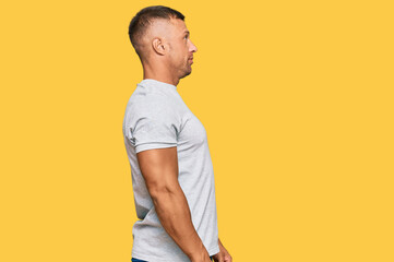 Poster - Handsome muscle man wearing casual grey tshirt looking to side, relax profile pose with natural face with confident smile.