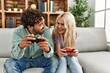 © Krakenimages.com - Young couple smiling happy playing video game at home.