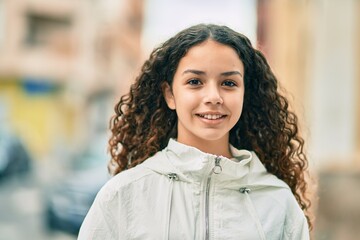 Wall Mural - Hispanic teenager girl smiling happy standing at the city.