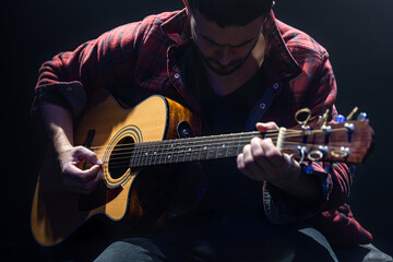 Wall Mural - Male guitarist playing acoustic guitar close up.