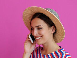 Wall Mural - Portrait of young girl with happy face while using smartphone isolated on pink background