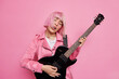 © wayhome.studio  - Carefree female musician tilts head sings favorite song plays electric guitar performs on stage being popular rock star jas trendy pink hair poses indoor. Music lifestyle show business concept
