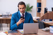© Elnur - Young male employee working at workplace