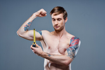 athlete with inflated torso bodybuilder Fitness tape measure and arm muscles strength