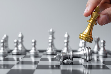 Wall Mural - businessman hand moving gold Chess King figure and Checkmate opponent during chessboard competition. Strategy, Success, management, business planning, disruption and leadership concept