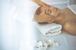 © rogerphoto - Beautiful brunette woman enjoying facial massage with closed eyes in sunny spa center. Relaxing treatment and cosmetic medicine concepts