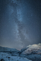 Sticker - Vertical shot of a beautiful snowy landscape under the Milky Way sky background