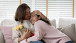 © ChayTee - Attractive beautiful asian middle age mum sit with grown up daughter give gift box and flower in family moment celebrate mother day. Overjoy bonding cheerful kid embrace relationship with retired mom.