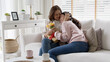 © ChayTee - Attractive beautiful asian middle age mum sit with grown up daughter give gift box and flower in family moment celebrate mother day. Overjoy bonding cheerful kid embrace relationship with retired mom.