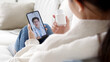 © ChayTee - Over shoulder view of young asia woman talk to doctor on cellphone videocall conference medical app in telehealth telemedicine online service hospital quarantine social distance at home concept.