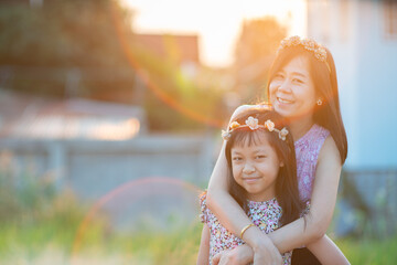 Smile mother hug daughter with beautiful light flare in background.Mother day concept