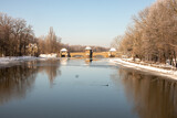 Fototapeta Tęcza - Winter view of the icy and snowy park and river landscapes in Leipzig, Saxony, Germany b