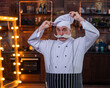 © Михаил Решетников - A friendly elderly male professional chef wearing an apron and a hat