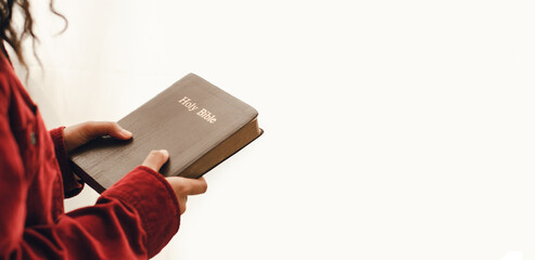 Wall Mural - A young woman standing and praying on the Bible, copy space. Beside the mirrored window