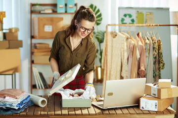 business owner woman using laptop and packing product