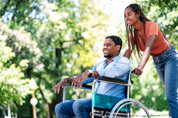 Man in a wheelchair enjoying a walk with his girlfriend.