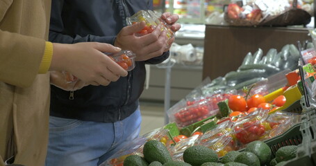 Man and woman buying vegetables in the supermarket