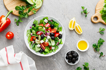 Canvas Print - Fresh vegetable greek salad with lettuce, olives and feta cheese, top view