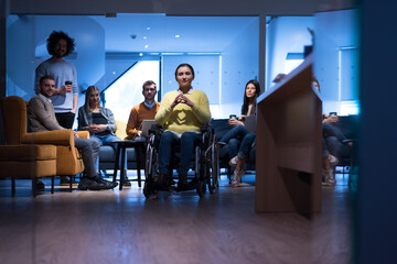 Office workers and person in a wheelchair discussing business moments in a modern office. Disability and business concept