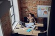 © Kostiantyn - High angle view of thoughtful interior designer woman looking at the window, holding glasses while sitting in modern office