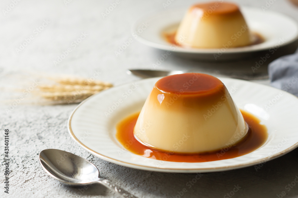 Obraz na płótnie Cream caramel pudding with caramel sauce in plate on white rustic table w salonie