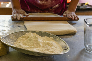 Wall Mural - Cook preparing a daugh with a wooden rolling pin