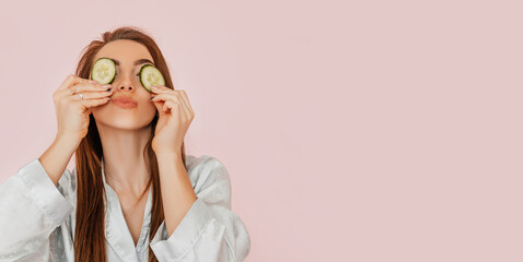 Wall Mural - girl make homemade face beauty masks. cucumbers for the freshness of the skin around the eyes. woman