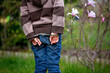Child, boy in handcuffs, standing backwards in garden