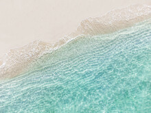 Aerial Top View Of Beautiful Tropical White Sand Beach With Wave Foam And Transparent Sea, Summer Vacation And Travel Background With Copy Space, Top View From Drone