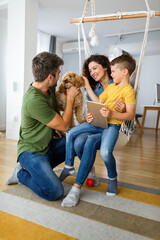 Wall Mural - Happy family with modern devices and dog having fun, playing at home