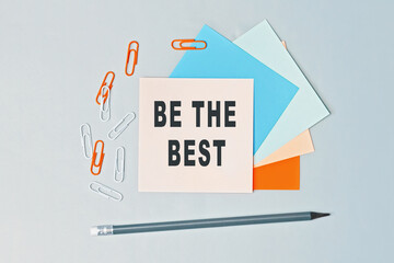 Be the best - text on sticky note paper on gray background. Closeup of a personal agenda