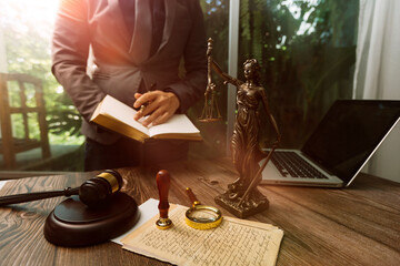 Justice and law concept.Male judge in a courtroom with the gavel, working with, computer and docking keyboard, eyeglasses, on table in morning light