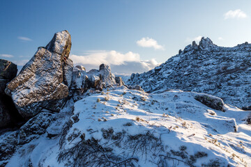 Wall Mural - Winter mountain landscape. View of the snow-capped rocks. Snow on the rocky slopes of the mountain. Mountain Stone Crown, Magadan Region, Siberia, Russia. The harsh nature of the Magadan region.