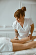 © Yaroslav Astakhov - Confident female specialist is doing anticellulite leg massage to beautiful healthy caucasian female client
