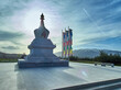 A buddhist stupa in the Plana mountain in Bulgaria against a sky backdrop with flags next to it