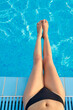 © verona_studio - Sexy female legs at blue water of swimming pool. Sun Protection.Sun Cream. Skin and Body Care.