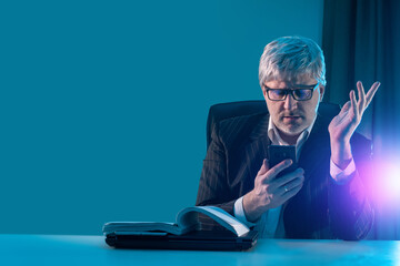 Poster - A businessman reads information on a smartphone. Business news. Information for entrepreneurs. Quotations of securities. A man in a business suit with a smartphone in his hands.