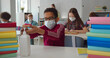 © TommyStockProject - Afro-american schoolboy in safety mask applying hand sanitizer during lesson