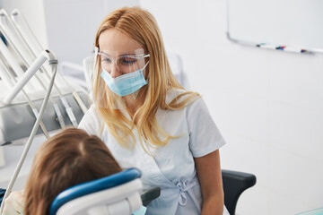 Sticker - Orthodontist taking care of her small patient