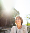 © mimagephotos - Close up smiling older woman with eyeglasses outside