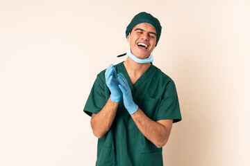 Wall Mural - Surgeon man in blue uniform over isolated background laughing