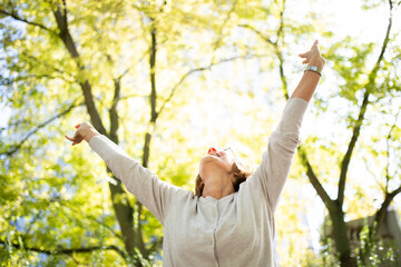 happy woman with arms outstretched in nature