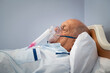 © Rido - Hospitalized senior patient lying on bed with oxygen mask at hospital