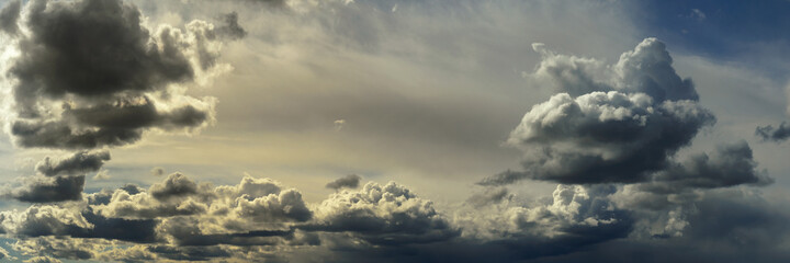 Wall Mural - wide panoramic view of the unbelievably beautiful sky with cumulus clouds and sunlight in a light atmospheric haze