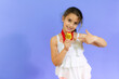 © Danko - Little girl showing her golden medal over purple background.