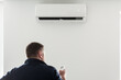 © Yurii Klymko - the service technician adjusts the new air conditioner