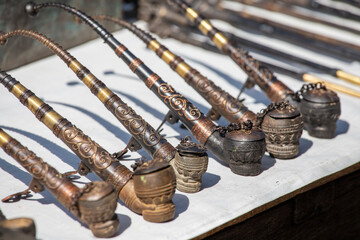 Wall Mural - Handmade decorative smoking pipes for opium and other souvenir in a tourist stall on street market in Burma, Myanmar