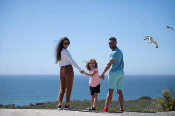 Wall Mural - Back view of carefree family on the beach vacation. Lifestyle family.